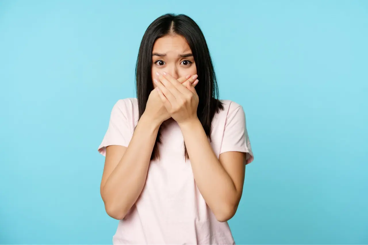 woman covering her mouth and looking shock