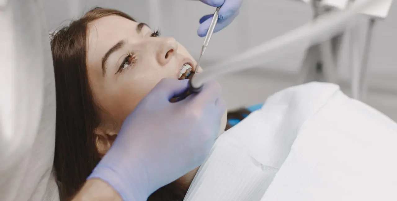 a girl receiving scaling treatment at a dental